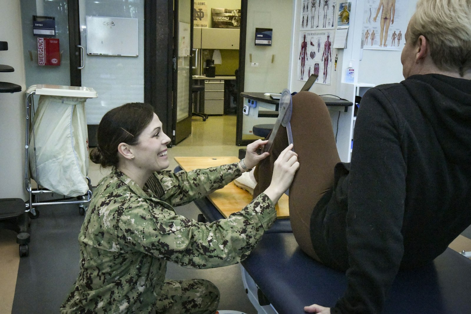 A physical therapist assesses an athlete's leg inside an integrated sports medicine clinic